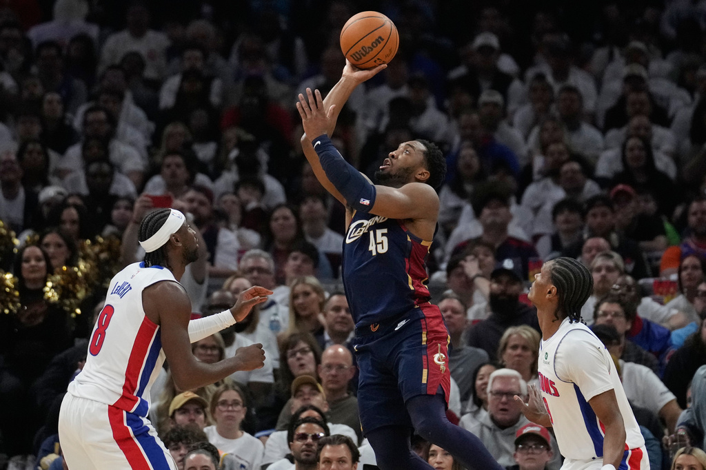 Cleveland Cavaliers' Donovan Mitchell (45) shoots between Detroit Pistons' Caris LeVert, left, and Ausar Thompson, right, in the second half of Game 4 of a second-round NBA basketball playoff series Monday, May 11, 2026, in Cleveland. (AP Photo/Sue Ogrocki)