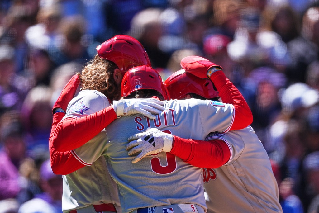 From left to right, Philadelphia Phillies' Alec Bohm, Bryson Stott and Brandon Marsh celebrate as Marsh crosses home plate after hitting a three-run home run off Colorado Rockies starting pitcher Michael Lorenzen in the first inning of a baseball game Friday, April 3, 2026, in Denver. (AP Photo/David Zalubowski)