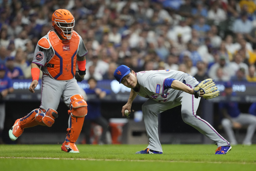 New York Mets' Kodai Senga looks to first base after fielding a ball hit in the infield during the fifth inning of a baseball game against the Milwaukee Brewers, Friday, Aug. 8, 2025, in Milwaukee. (AP Photo/Aaron Gash)