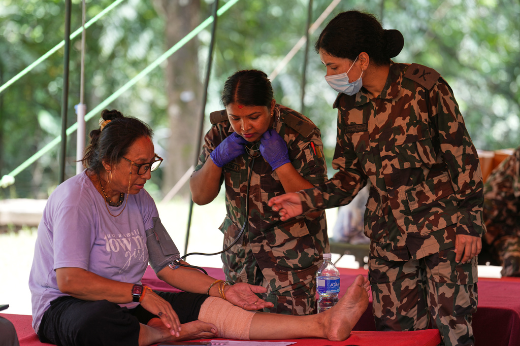 Nepalese army doctors treat a woman rescued from flash flooding at an army camp in Nepal's Nuwakot district, Friday, Aug. 28, 2026. (AP Photo/Rajesh Kumar Singh)