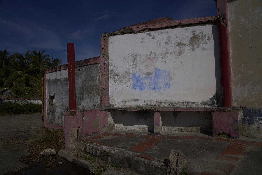 A barely visible mural of late President Hugo Chávez fades from a wall near the international port in Güiria, on Venezuela's Paria Peninsula, Saturday, Sept. 13, 2025. (AP Photo/Ariana Cubillos)