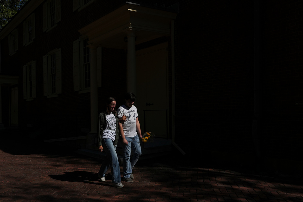 Newlywed couple, Emily Philbrook and Benjamin Barger, walk out of a worship service at the Quaker Arch Street Meeting House in Philadelphia on Oct. 5, 2025. (AP Photo/Luis Andres Henao)