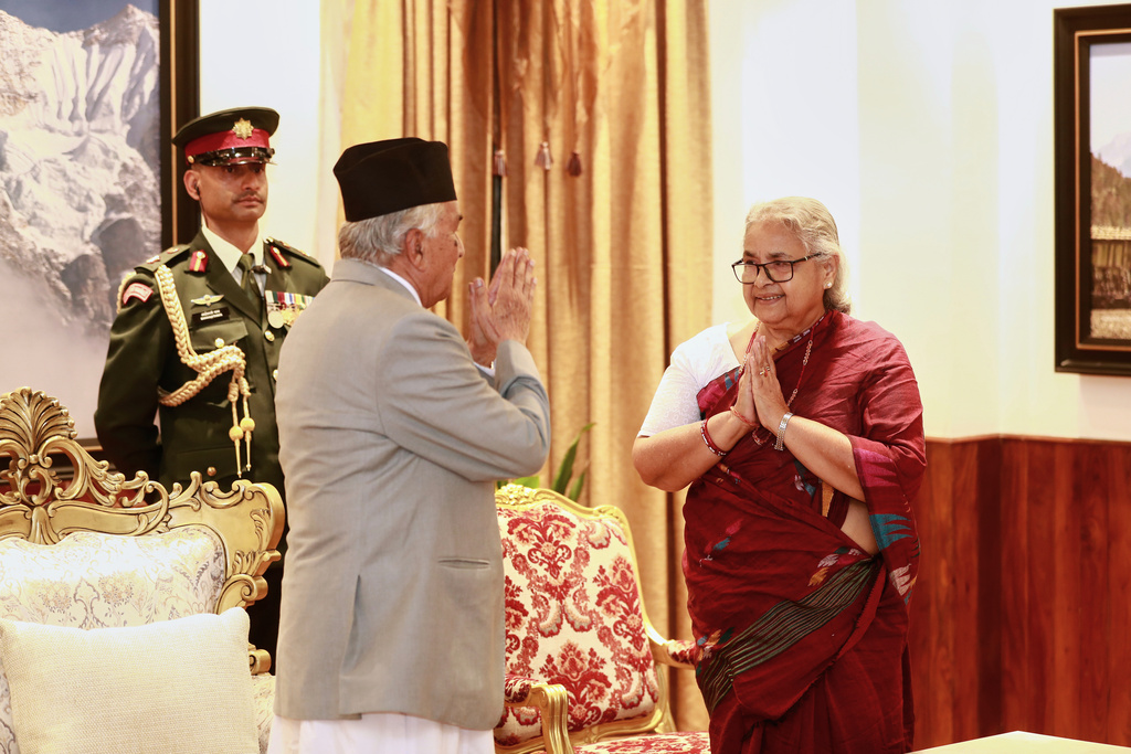Former Supreme Court Chief Justice Sushila Karki, right, greets Nepalese President Ram Chandra Poudel after taking the oath as interim prime minister during a ceremony at the presidential residence in Kathmandu, Nepal, Friday, Sept. 12, 2025. (AP Photo/Sujan Gurung)
