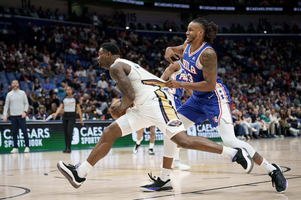 New Orleans Pelicans forward Zion Williamson, left, is grabbed by Philadelphia 76ers forward Jabari Walker, right, during the first half of an NBA basketball game in New Orleans, Saturday, Feb. 21, 2026. (AP Photo/Matthew Hinton)
