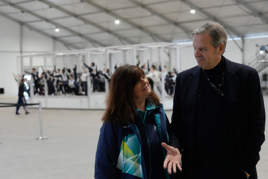 FILE - Creative Director and Executive Producer Marco Balich speaks with director of ceremonies Maria Laura Iascone as volunteer dancers perform during rehearsals for the opening ceremony of the Milan Cortina 2026 Winter Olympic Games, at a compound in a big tent next to San Siro Stadium, in Milan, Italy, Saturday, Jan. 24, 2026. (AP Photo/Luca Bruno, File)