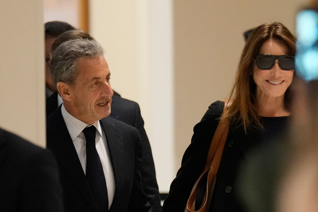 Former French President Nicolas Sarkozy and his wife Carla Bruni Sarkozy arrive to the courtroom for his verdict for alleged illegal financing of his 2007 presidential campaign by the government of then-Libyan leader Moammar Gadhafi, Thursday, Sept. 25, 2025 in Paris. (AP Photo/Michel Euler)