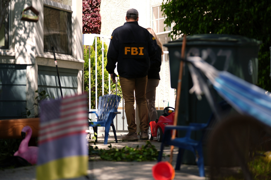 FBI agents work in a neighbor's yard, Sunday, April 26, 2026, near an address in Torrance, Calif., connected to Cole Tomas Allen, who was identified as the shooting suspect at the White House Correspondents Dinner the night before. (AP Photo/Damian Dovarganes)