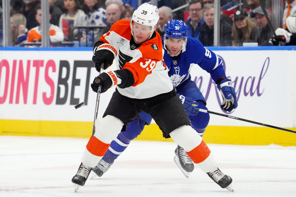 Philadelphia Flyers' Matvei Michkov (39) passes the puck while under pressure from Toronto Maple Leafs' John Tavares (91) during first-period NHL hockey game action in Toronto, Monday, March 2, 2026. (Frank Gunn/The Canadian Press via AP)
