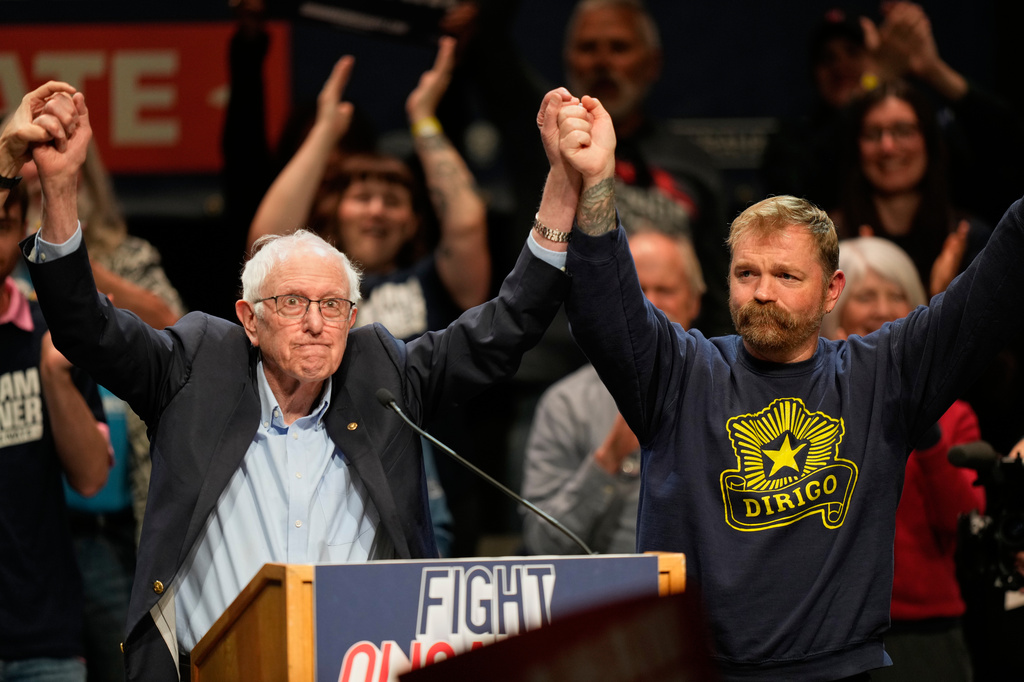 Graham Platner, Democratic candidate for U.S. Senate, and Sen. Bernie Sanders, left, join hands at an event in Orono, Maine, Sunday, May 24, 2026. (AP Photo/Robert F. Bukaty)