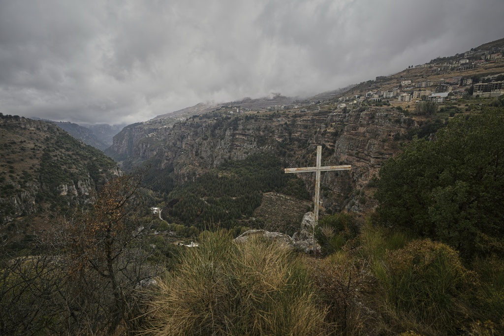 A cross stands on a cliff overlooking the Kadisha Valley, a holy site for Lebanon's Maronite Christians, near the northeast mountain town of Bcharre, Lebanon, Saturday, Nov. 15, 2025. (AP Photo/Hassan Ammar)