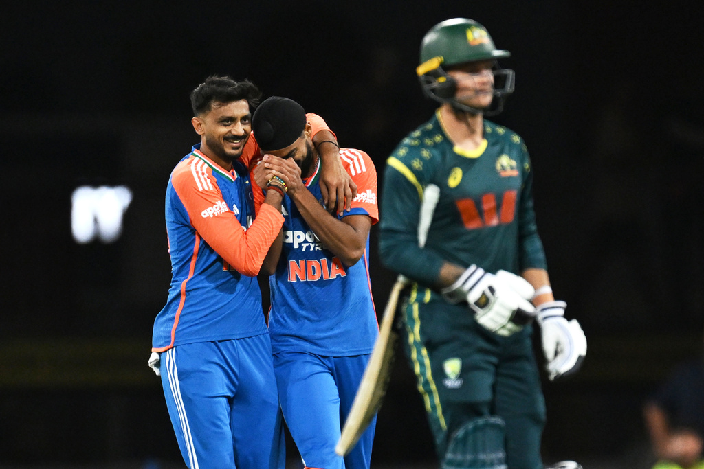 Indian bowler Arshdeep Singh, centre, is congratulated by teammate Axar Patel after dismissing Australian batsman Josh Philippe, right, during a T20 cricket international between India and Australia in Carrara, Australia, Thursday, Nov.6, 2025. (Dave Hunt/AAPImage via AP)