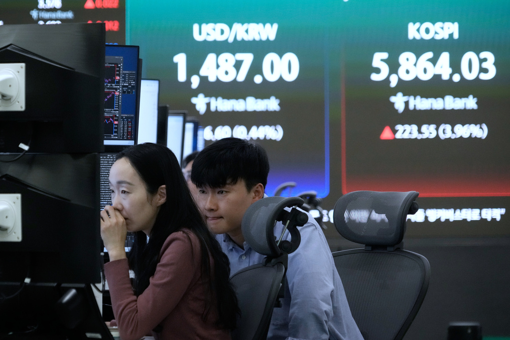 Currency traders watch monitors near a screen showing the Korea Composite Stock Price Index (KOSPI), top right, at the foreign exchange dealing room of the Hana Bank headquarters in Seoul, South Korea, Wednesday, March 18, 2026. (AP Photo/Ahn Young-joon)