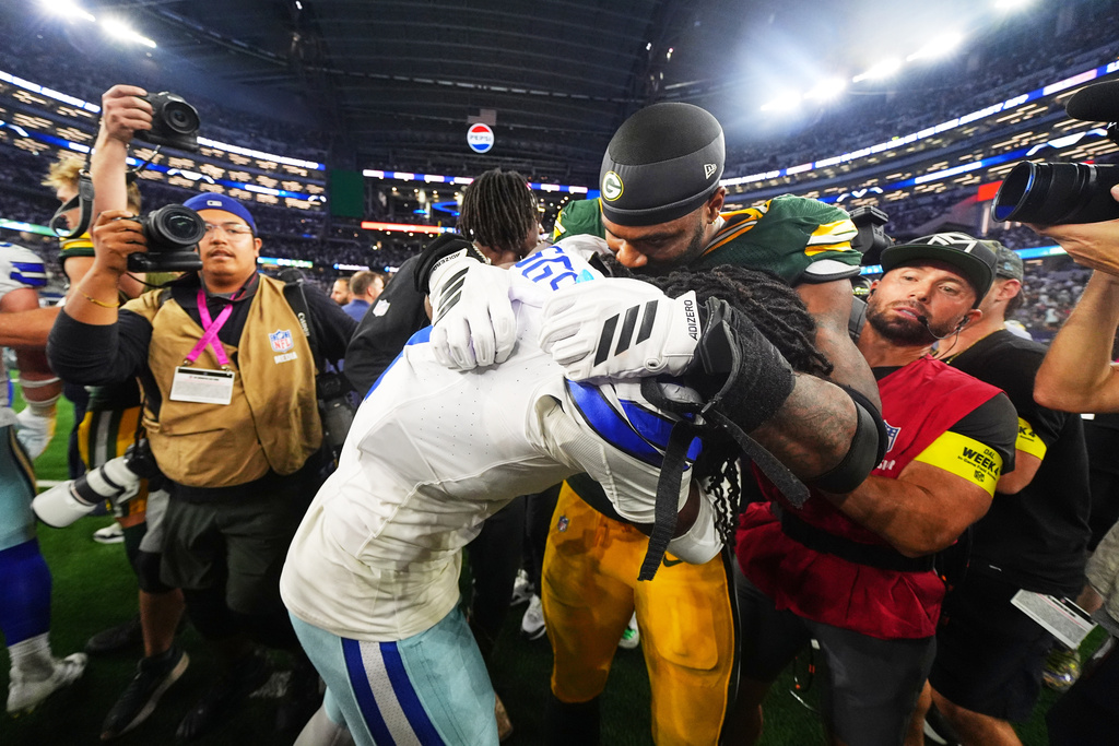 Dallas Cowboys cornerback Trevon Diggs, left, and Green Bay Packers' Micah Parsons, right, joke with each other after an NFL football game Sunday, Sept. 28, 2025, in Arlington, Texas. (AP Photo/Julio Cortez)