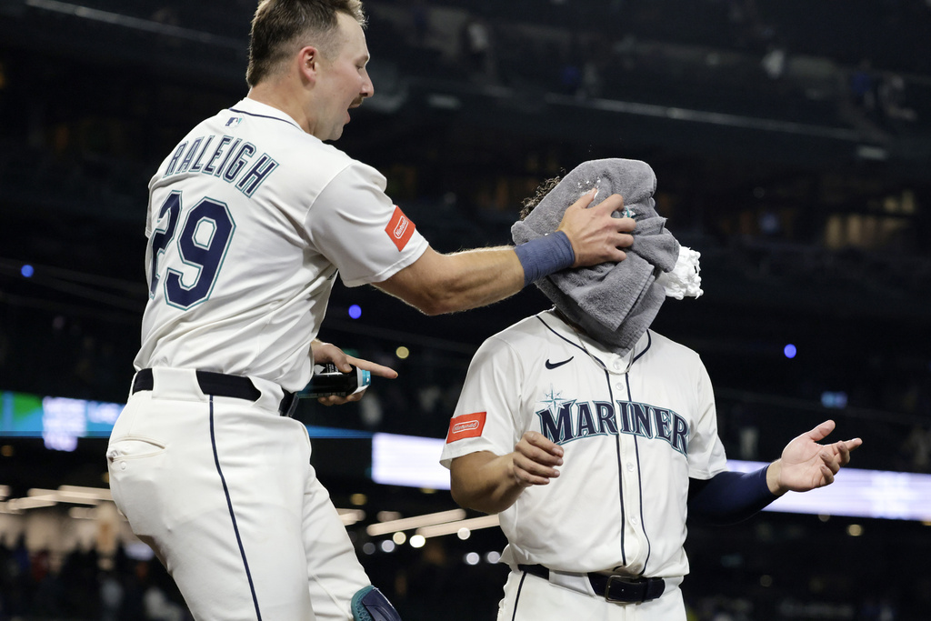 Seattle Mariners' Cal Raleigh hits Leo Rivas with shaving cream as they celebrate his two RBI walk-off home run off St. Louis Cardinals pitcher Ryan Fernandez during the 13th inning of a baseball game Wednesday, Sept. 10, 2025, in Seattle. (AP Photo/John Froschauer)