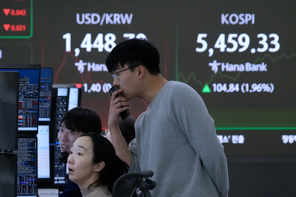 Currency traders watch monitors near a screen showing the Korea Composite Stock Price Index (KOSPI), right, and the foreign exchange rate between U.S. dollar and South Korean won at the foreign exchange dealing room of the Hana Bank headquarters in Seoul, South Korea, Thursday, Feb. 12, 2026. (AP Photo/Ahn Young-joon)