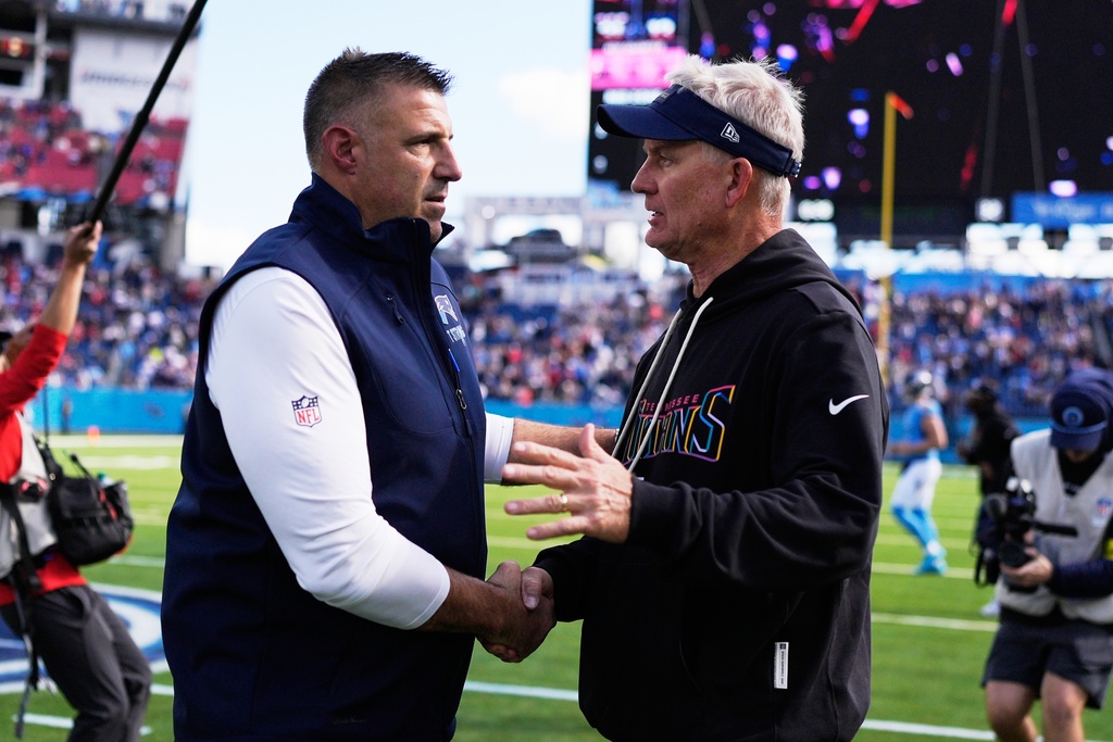 New England Patriots head coach Mike Vrabel, left, shakes hands with Tennessee Titans interim head coach Mike McCoy following an NFL football game, Sunday, Oct. 19, 2025, in Nashville, Tenn. (AP Photo/George Walker IV)