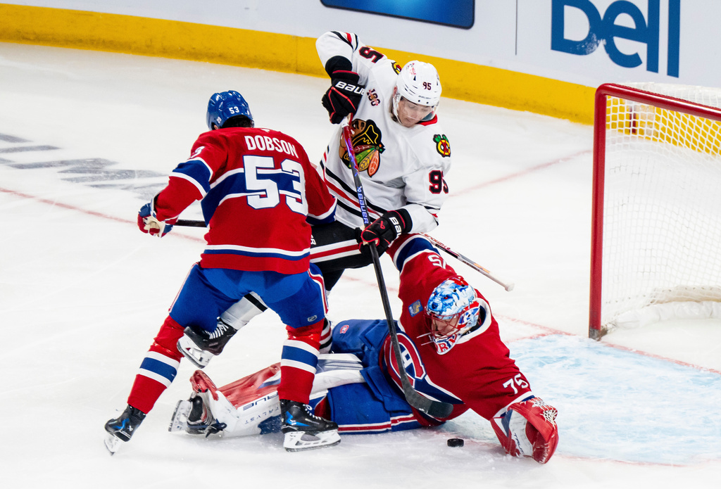 Chicago Blackhawks' Ilya Mikheyev (95) makes contact with Montreal Canadiens goaltender Jakub Dobes (75) while Candians' Noah Dobson (53) defends during first-period NHL hockey game action in Montreal, Thursday, Dec. 18, 2025. (Christopher Katsarov/The Canadian Press via AP)