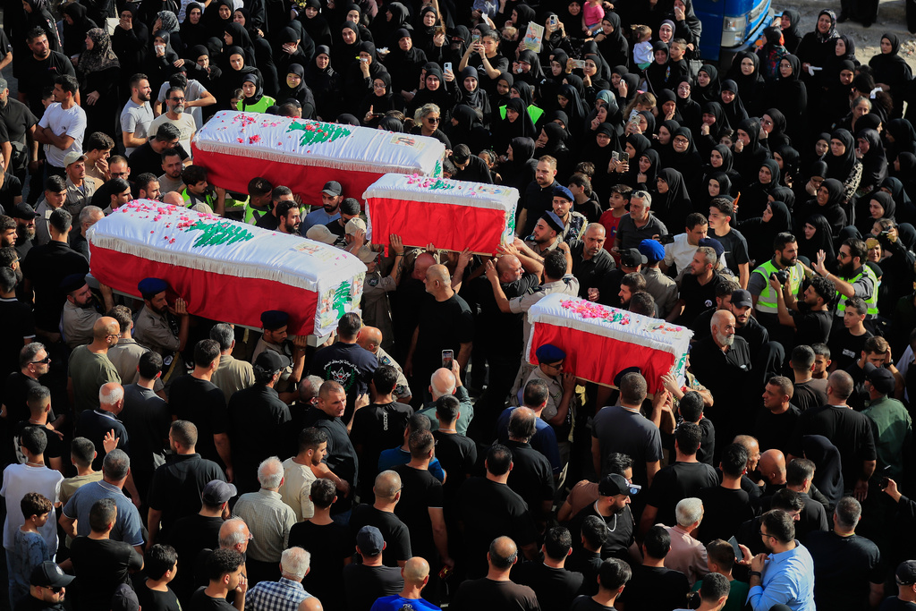 Mourners carry the coffins of four family members killed Sunday in an Israeli drone strike that hit their car, during a funeral procession in Bint Jbeil, southern Lebanon, Tuesday, Sept. 23, 2025. (AP Photo/Mohammed Zaatari)