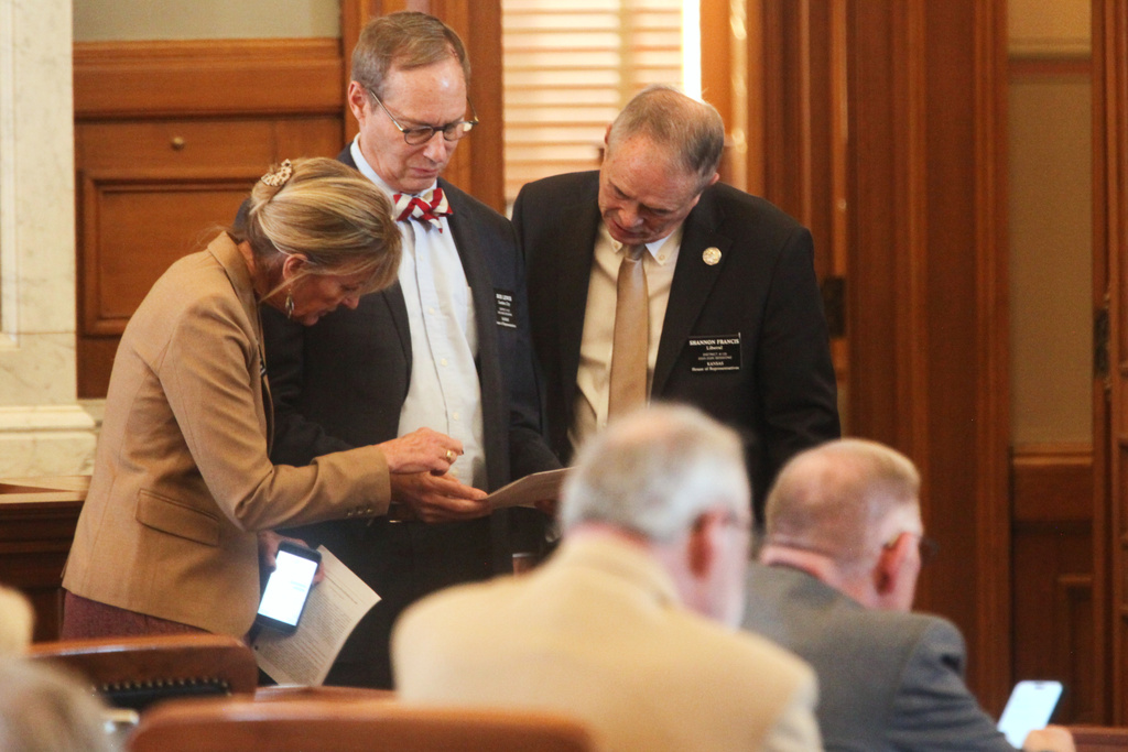 Kansas State Reps. Susan Humphries, left, R-Wichita; Bob Lewis, center, R-Garden City, and Shannon Francis, right, R-Liberal, confer during a House debate on a measure to prevent transgender people from changing their driver's licenses and birth certificates to reflect their gender identities and invalidate any past changes made for them, Wednesday, Jan. 28, 2026, at the Statehouse in Topeka, Kan. (AP Photo/John Hanna)