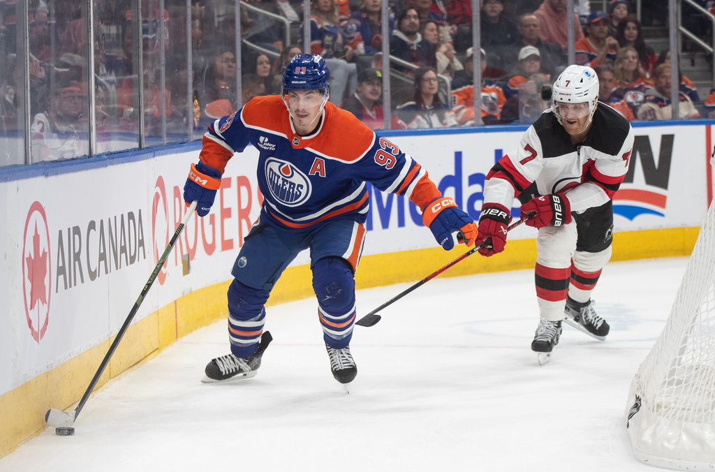 New Jersey Devils' Dougie Hamilton (7) chases Edmonton Oilers' Ryan Nugent-Hopkins (93) during the second period of an NHL hockey game in Edmonton on Tuesday, Jan. 20, 2026. (Jason Franson/The Canadian Press via AP)