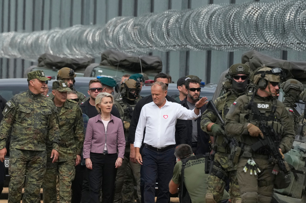 FILE -Polish Prime Minister Donald Tusk, centre right, and European Commission President Ursula von der Leyen, centre left, speak to Border Guard personnel during their visit to the Polish-Belarus border, in Krynki, Poland, Aug. 31, 2025. (AP Photo/Czarek Sokolowski, File)