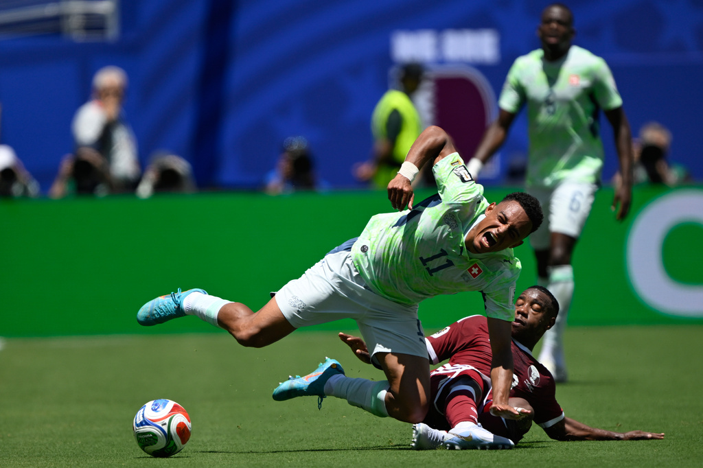 Switzerland's Dan Ndoye. left, is brought down by Qatar's Assim Madibo during the World Cup Group B soccer match between Qatar and Switzerland in Santa Clara, Calif., near San Francisco, Saturday, June 13, 2026. (AP Photo/Eakin Howard)