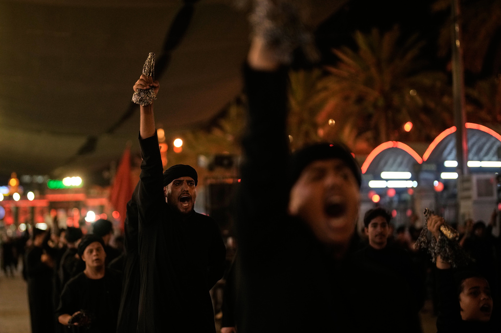 Shiite mourners chant slogans as the perform ritual self-flagellation with chains outside the Imam Hussein Shrine on the eve of funeral ceremonies for the late Iranian Supreme Leader Ayatollah Ali Khamenei in Karbala, Iraq, Tuesday, July 7, 2026. (AP Photo/Khalil Hamra)