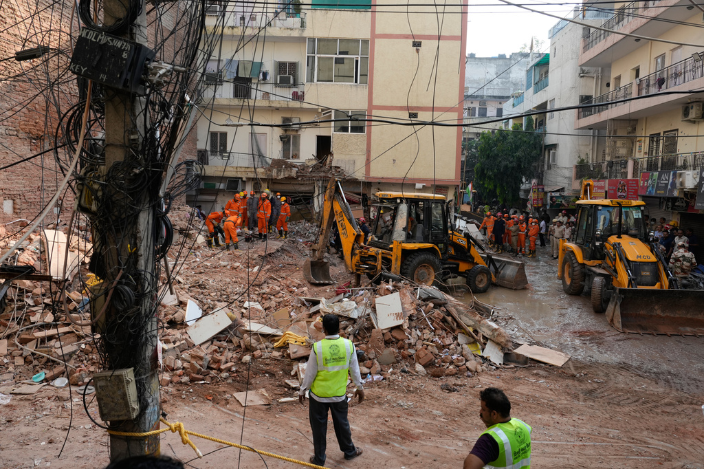 Rescuers clear debris as they search for people possibly trapped at the site of a collapsed building in New Delhi, India, Monday, Sept. 7, 2026. (AP Photo/Manish Swarup)