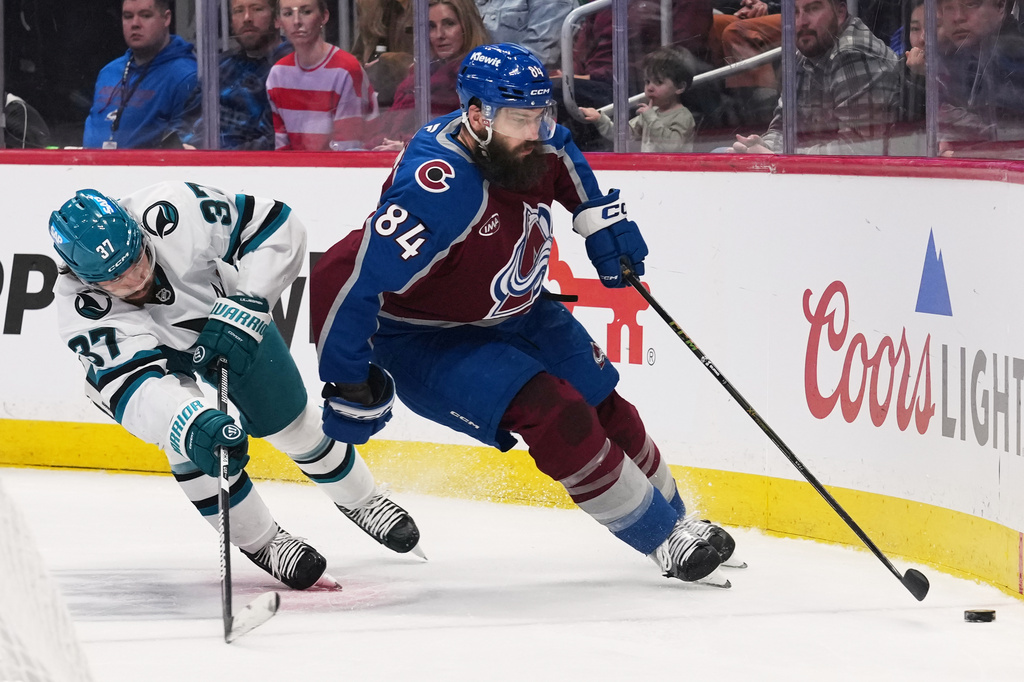 FILE - Colorado Avalanche defenseman Brent Burns, right, collects the puck as San Jose Sharks defenseman Timothy Liljegren pursues in the third period of an NHL hockey game, Feb. 4, 2026, in Denver. (AP Photo/David Zalubowski, File)