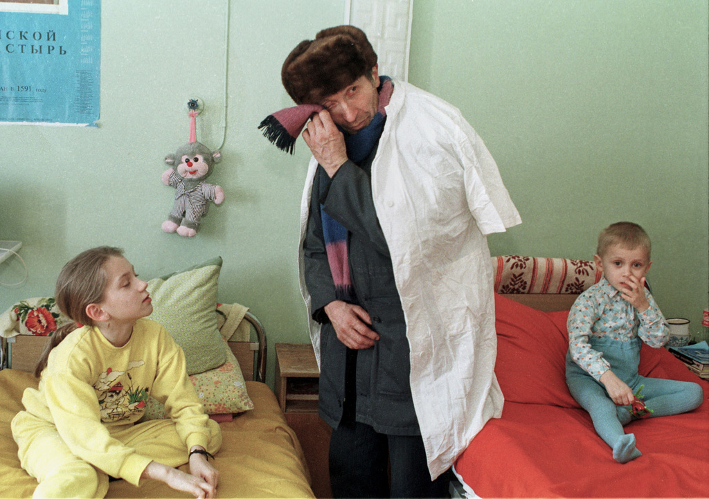 FILE - Ivan Kalenda turns away to wipe his tears as he visits his 3-year-old grandson Vitya, right, in the children's cancer hospital ward in Gomel, Belarus, March 19, 1996, nearly a decade after the explosion and fire at the Chernobyl nuclear power plant that sent radioactive clouds through Ukraine, Belarus and other parts of Europe. (AP Photo/Efrem Lukatsky, File)