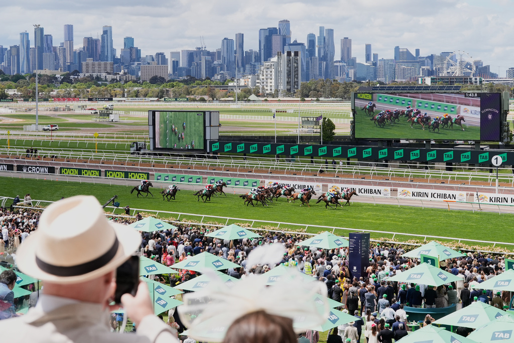 Spectators watch a race ahead of the Melbourne Cup horse race in Melbourne, Australia, Tuesday, Nov. 4, 2025. (AP Photo/Asanka Brendon Ratnayake)