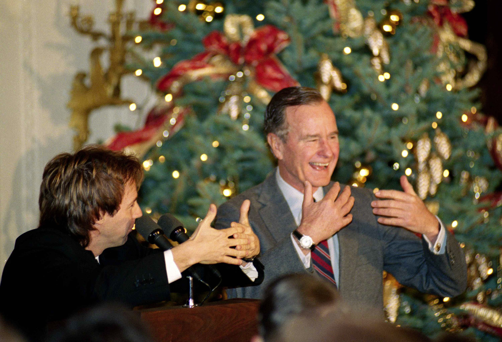 FILE - Comic Dana Carvey, left, shows President George H.W. Bush how to imitate himself, Dec. 8, 1992, at the White House in Washington. (AP Photo/Dennis Cook, File)