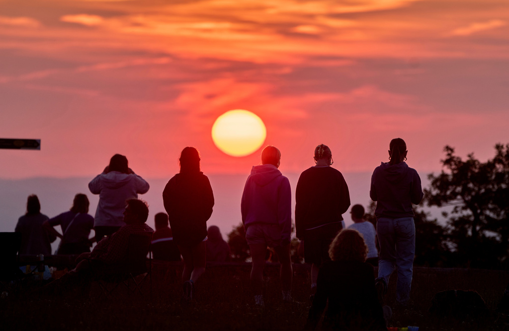 FILE - People gather on top of the Feldberg mountain to watch the sunset near Frankfurt, Germany, June 21, 2025. (AP Photo/Michael Probst, File)
