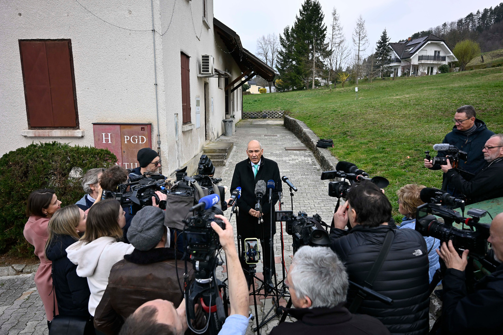 Former Slovenian Prime Minister Janez Jansa, center, speaks to the media outside a polling station for parliamentary elections in Arnace, Slovenia, Sunday, March 22, 2026. (AP Photo/Denes Erdos)
