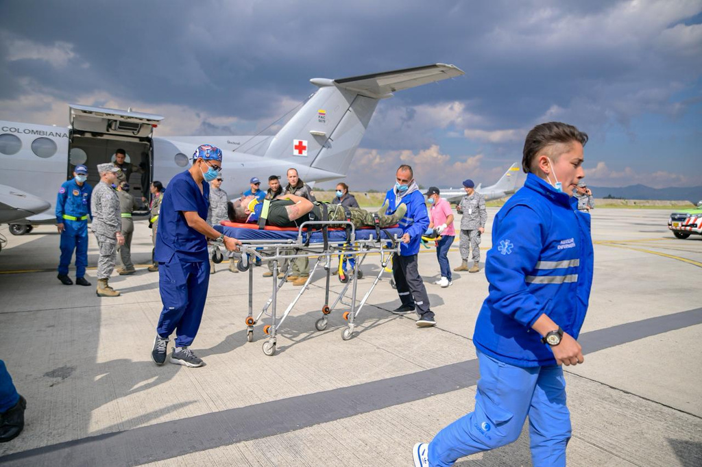 In this photo distributed by Colombia's Armed Forces press office, people who were injured on a military cargo plane that crashed shortly after takeoff in Puerto Leguizamo, arrives at a military base for treatment in Bogota, Colombia, Monday, March 23, 2026. (Colombia's Armed Forces press office via AP)