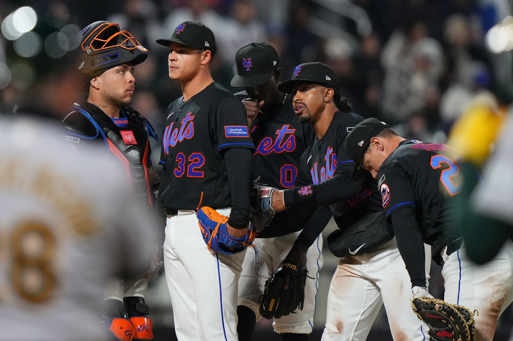 New York Mets' Francisco Lindor, right, and Francisco Alvarez, left, encourae pitcher Tobias Myers (32) before he leaves during the ninth inning of a baseball game against the Athletics Friday, April 10, 2026, in New York. (AP Photo/Frank Franklin II)