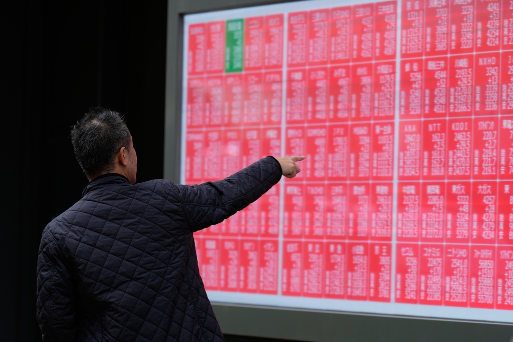 A person loots at an electronic stock board showing Japan's Nikkei index at a securities firm Monday, Oct. 27, 2025, in Tokyo. (AP Photo/Eugene Hoshiko)