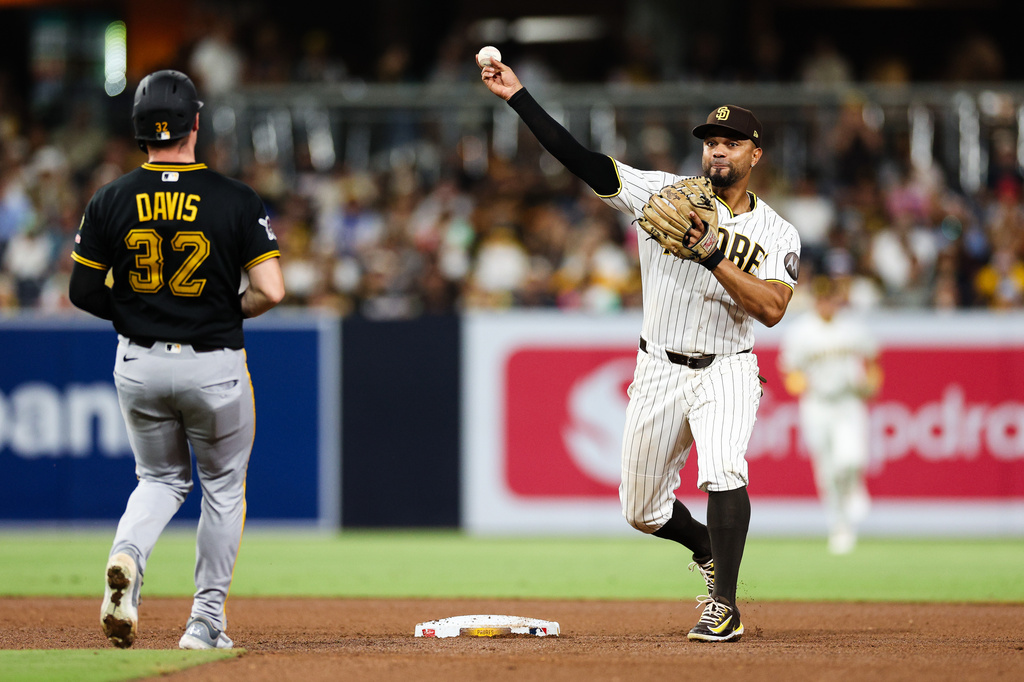 San Diego Padres shortstop Xander Bogaerts, right, throws to first to complete a double play after forcing out Pittsburgh Pirates' Henry Davis at second base on a ball hit by Spencer Horwitz in the fifth inning of a baseball game, Tuesday, Aug. 25, 2026, in San Diego. (AP Photo/Derrick Tuskan)