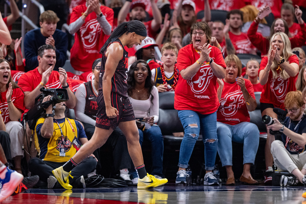 Indiana Fever guard Shey Peddy, front left, reacts after being fouled during the first half of Game 4 of a WNBA basketball playoff semifinals series against the Las Vegas Aces in Indianapolis, Sunday, Sept. 28, 2025. (AP Photo/Doug McSchooler)