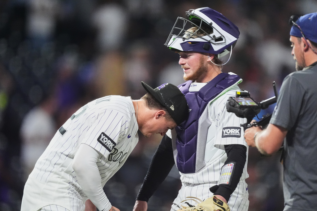 Colorado Rockies' Mickey Moniak, left, congratulates catcher Hunter Goodman after defeating the Washington Nationals in a baseball game, Tuesday, July 21, 2026, in Denver. (AP Photo/David Zalubowski)