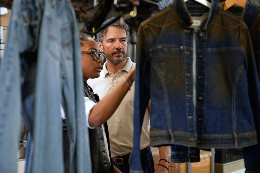 Bill Curtin, owner of BPD Washhouse, looks over some samples at his denim processing facility in Jersey City, N.J., Tuesday, May 5, 2026. (AP Photo/Seth Wenig)
