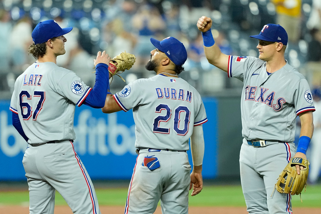 Texas Rangers' Jacob Latz (67) Ezequiel Duran (20) and Josh Jung, right, celebrate after their baseball game against the Kansas City Royals, Wednesday, June 10, 2026, in Kansas City, Mo. (AP Photo/Charlie Riedel)