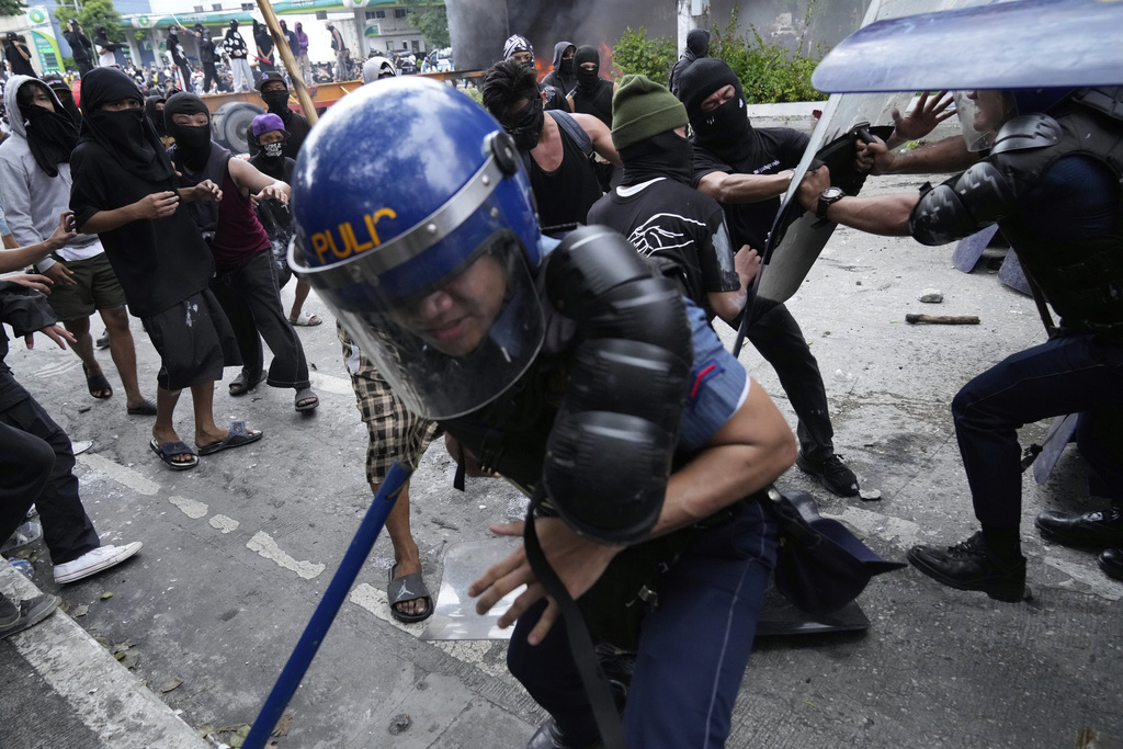 Police escape protesters during a scuffle as they tried to enter the Malacanang presidential palace compound in Manila, Philippines, on Sunday, Sept. 21, 2025. (AP Photo/Aaron Favila)