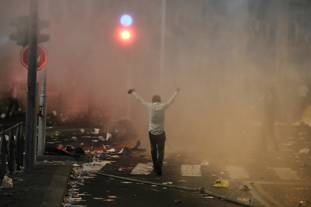 An ultra-Orthodox Jewish man stands in front of a police water cannon during a protest against plans to require ultra-Orthodox men to serve in the Israeli military, in Jerusalem, Thursday, Oct. 30, 2025. (AP Photo/Leo Correa)
