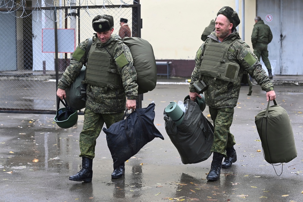 FILE - Recruits carry their gear at a military recruitment center in Rostov-on-Don, Russia, Oct. 31, 2022. (AP Photo, File)