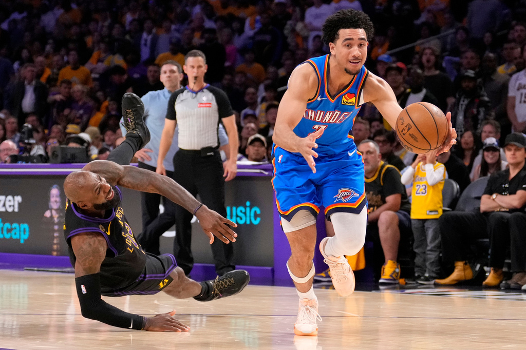 Oklahoma City Thunder guard Jared McCain, right, drives toward the basket as Los Angeles Lakers forward LeBron James falls during the second half of Game 4 in a second-round NBA basketball playoffs series Monday, May 11, 2026, in Los Angeles. (AP Photo/Mark J. Terrill)