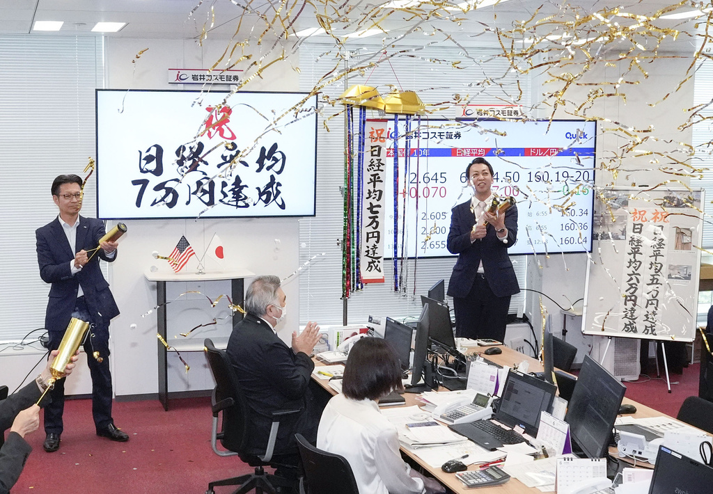 Employees of a securities company celebrate as Japan's benchmark Nikkei 225 topped 70,000 for the first time during trading hours in Tokyo Tuesday, June 16, 2026. A sign, left, reads " Congratulations. Nikkei index reached 70,000 yen." (Shinji Kouchi/Kyodo News via AP)
