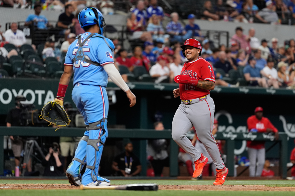 Los Angeles Angels' Moisés Ballesteros, right, scores on a sacrifice fly by Josh Lowe as Texas Rangers catcher Elias Díaz (35) looks on in the eighth inning of a baseball game Sunday, Aug. 23, 2026, in Arlington, Texas. (AP Photo/Tony Gutierrez)