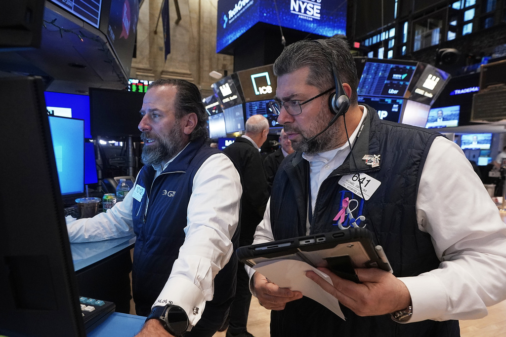 Specialist Michael Pistillo, left, and trader Michael Capolino work on the floor of the New York Stock Exchange, Friday, Jan. 16, 2026. (AP Photo/Richard Drew)