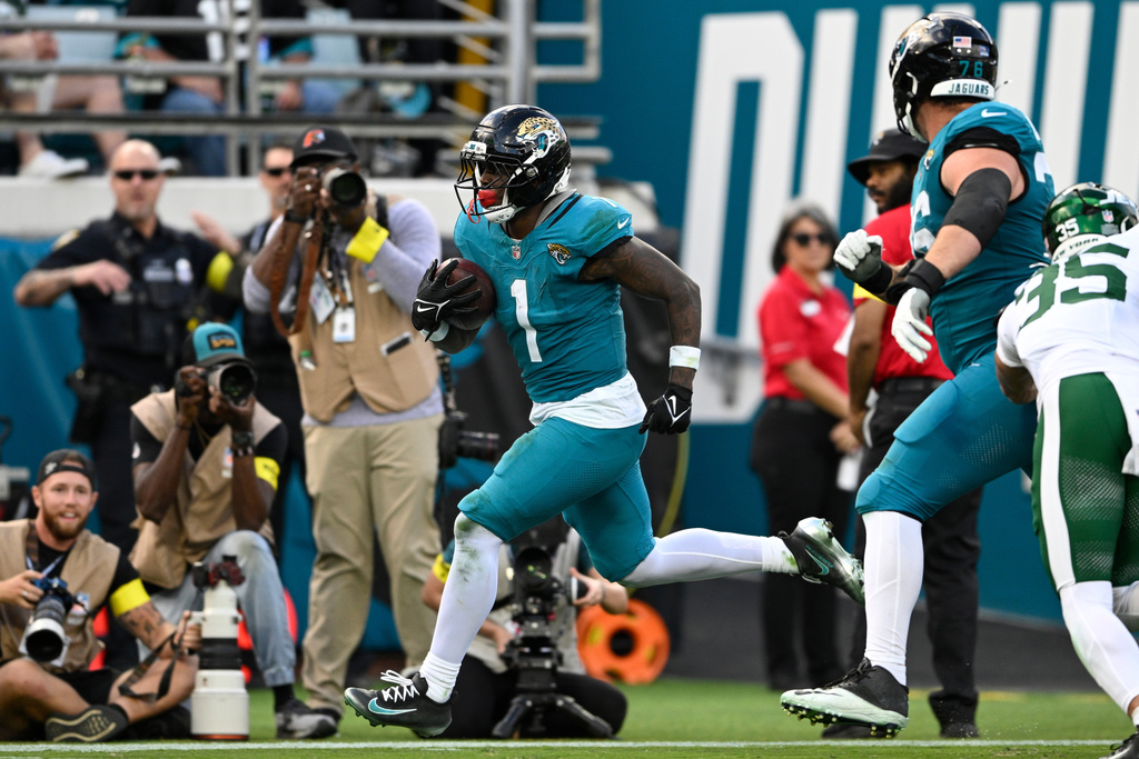 Jacksonville Jaguars running back Travis Etienne Jr. (1) runs for a touchdown against the New York Jets during the second half of an NFL football game, Sunday, Dec. 14, 2025, in Jacksonville, Fla. (AP Photo/Phelan M. Ebenhack)
